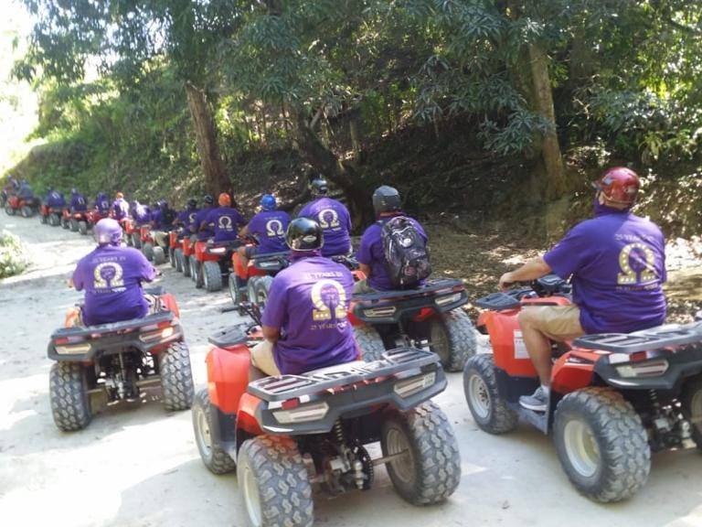 Line of ATV riders on a countryside excursion road