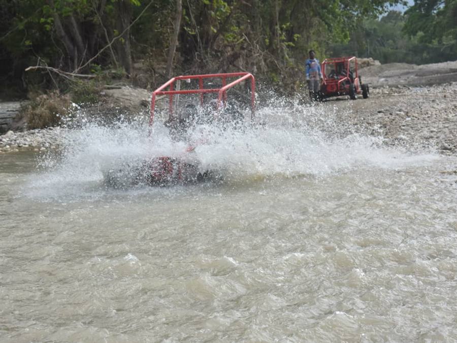 Dune buggy splashing through a river crossing